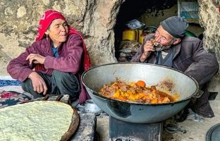 (ویدئو) پخت نان ساجی و یک غذای محلی با ران گوسفند توسط زوج غارنشین افغانستانی